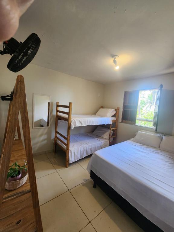 a bedroom with two bunk beds and a mirror at Casa Vista Mar - Iemanjá in Itacaré