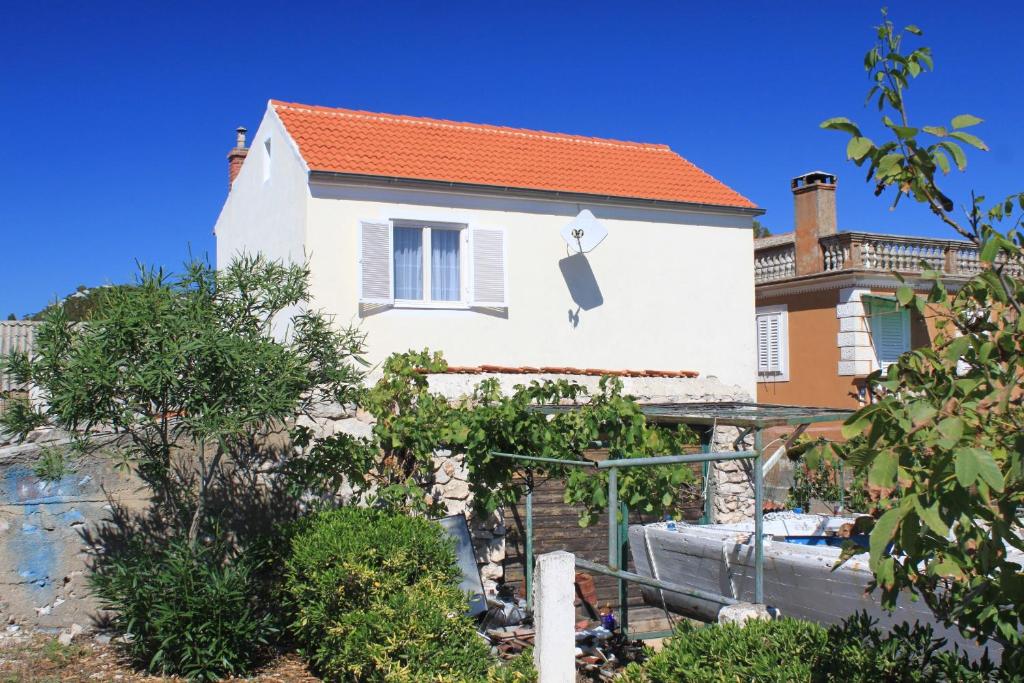 a house with a boat in front of it at Holiday house with a parking space Lukoran, Ugljan - 8385 in Lukoran