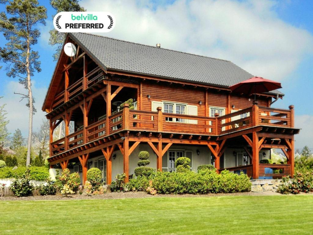 a large wooden house with a gambrel roof at Luxury Wellness Villa, Septon in Durbuy