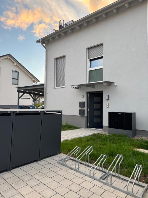 a white house with chairs in the yard at Haus am Vogesenblick - Ihr Zimmer mit Aussicht für bis zu 3 Personen in Bad Bellingen