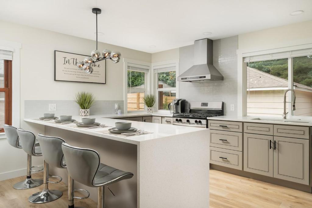 a kitchen with a large white counter and chairs at Modern Nest - Cozy & Free Parking in Edgewood