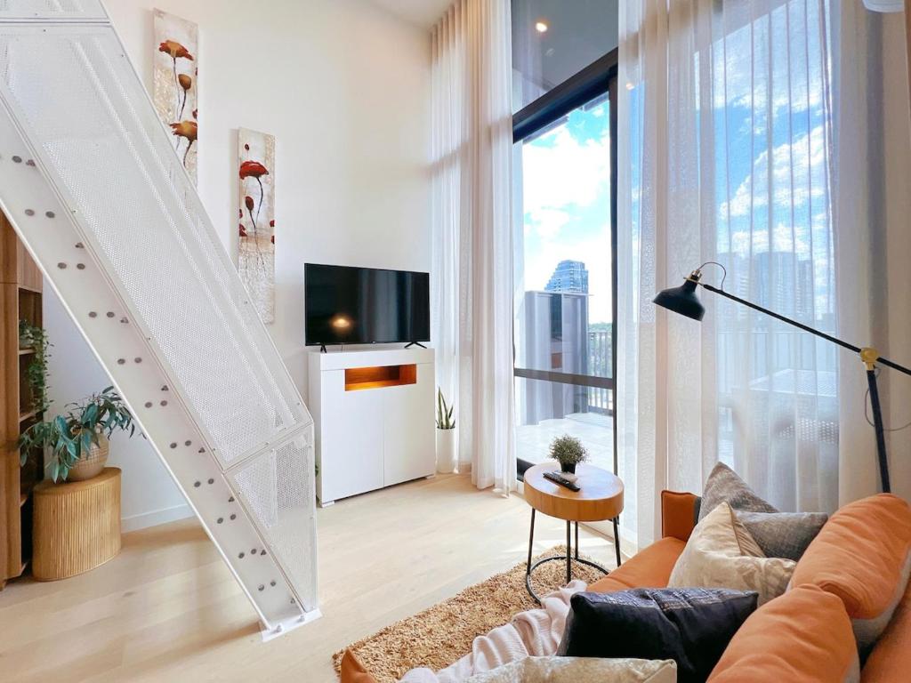 a living room with a couch and a large window at Convenient Loft Modern Stay Central Box Hill in Box Hill