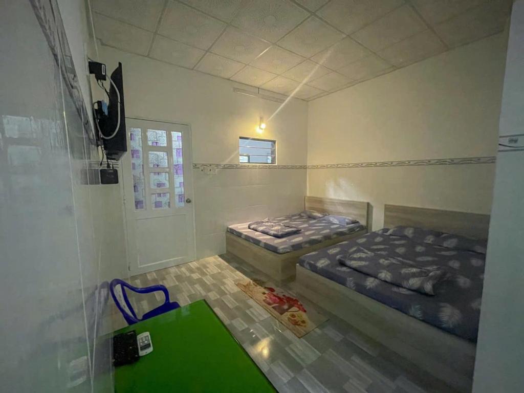 una camera con due letti e un tavolo verde di Thiên Thanh Long Hải Motel a Long Hai