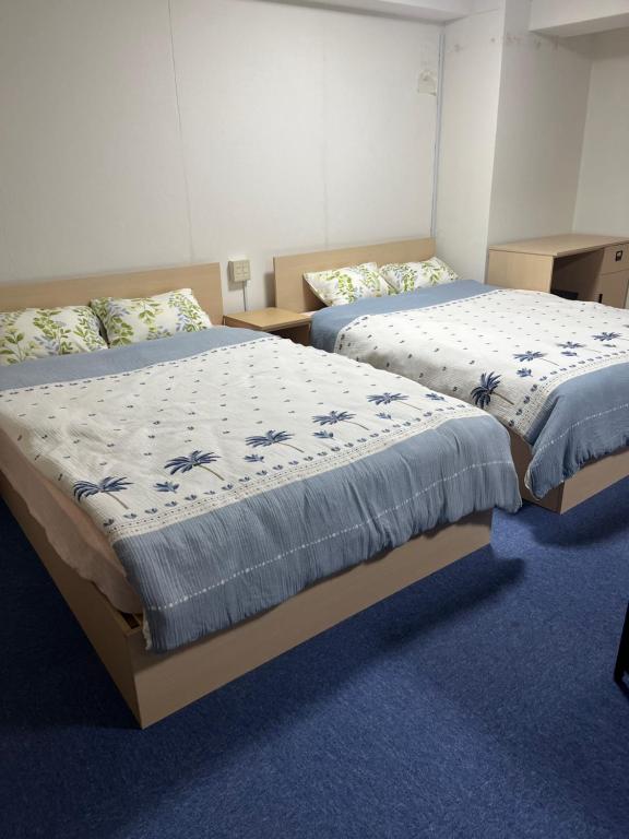 two beds sitting next to each other in a room at ひまわりHotel in Nagasaki