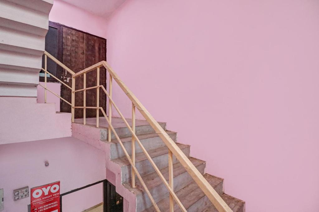 a staircase in a building with a white wall at Hotel O Knight guest house in Morādābād