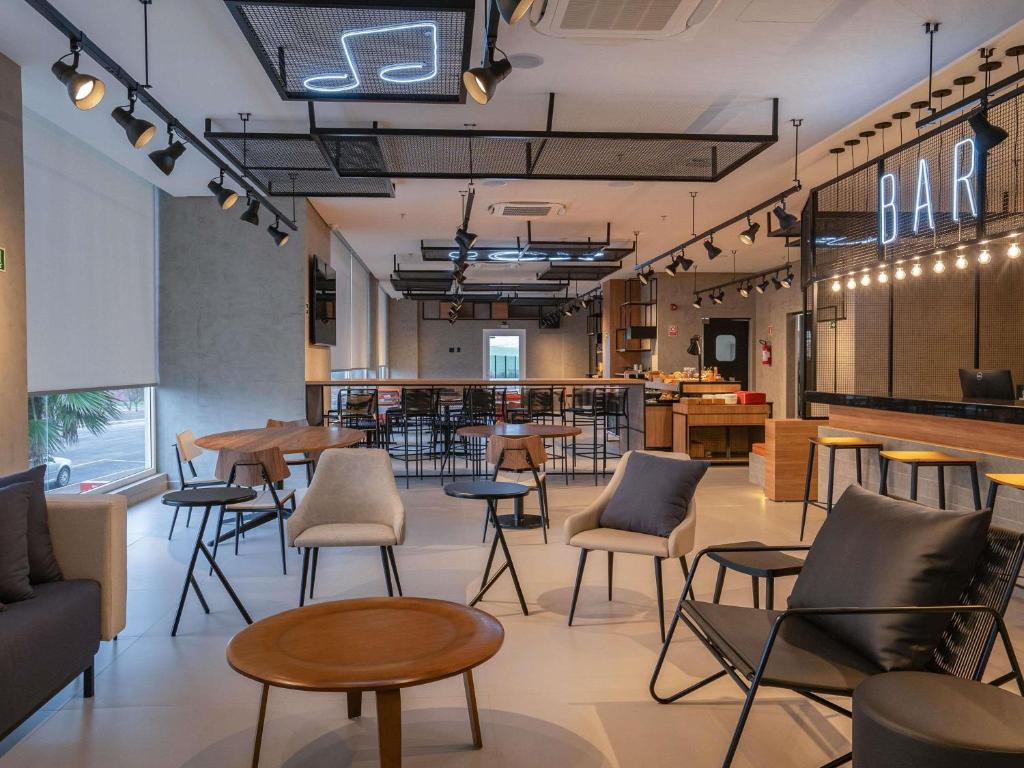 a restaurant with tables and chairs and a bar at ibis Guarapuava in Guarapuava