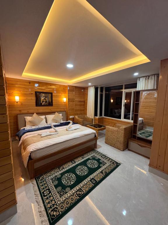 a bedroom with a large bed and a rug at Hotel North Hill in Tawang