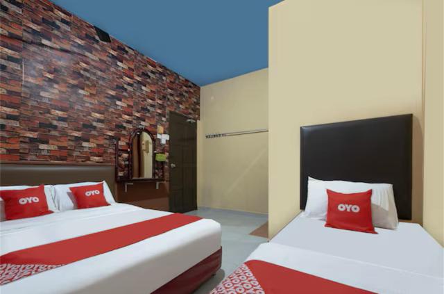 Kampong Salengにあるhotel hen henのレンガの壁、ベッド2台が備わるベッドルーム1室が備わります。