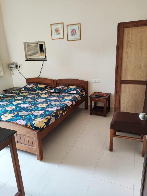 a bedroom with a bed and a table and a chair at Villa Candolim Goa in Candolim