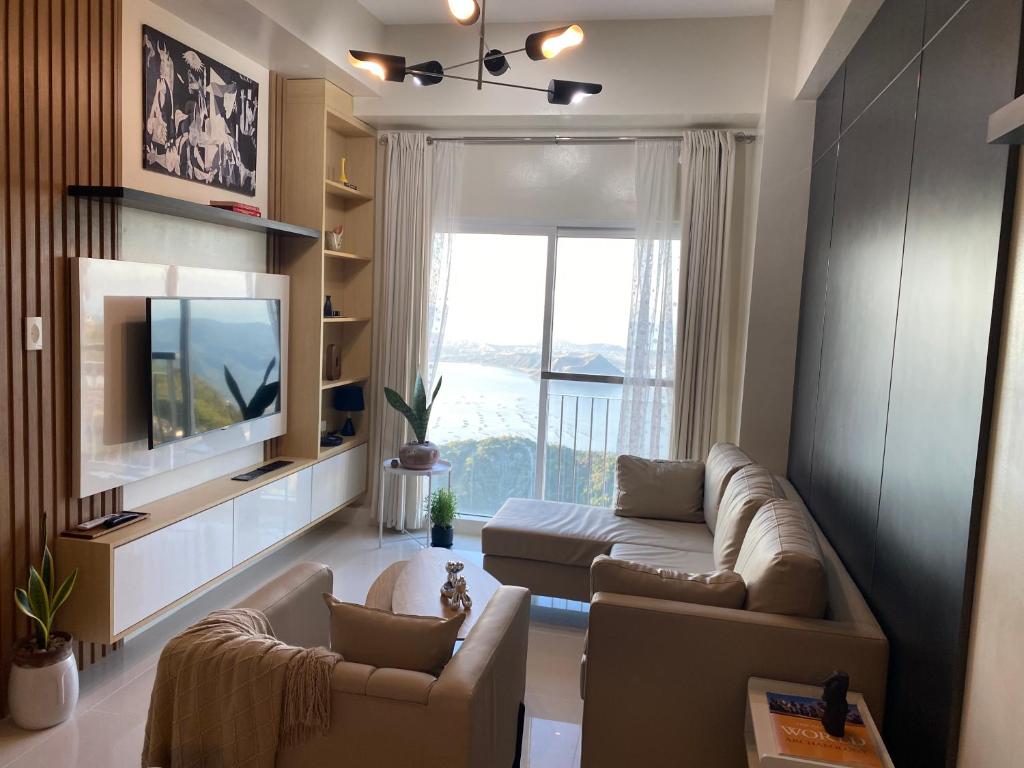 a living room with a couch and a tv at Idyllic Taal with Modern Vibe 2BR Condo Stunning View - Netflix - 3AC - WiFi in Tagaytay