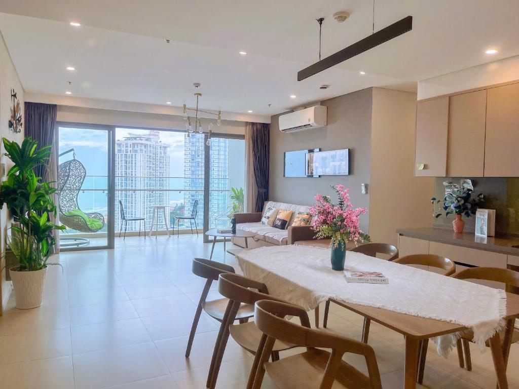 a kitchen and living room with a table and chairs at Căn Hộ The Sóng Condotel Vũng Tàu - Hao'sHomestay in Vung Tau