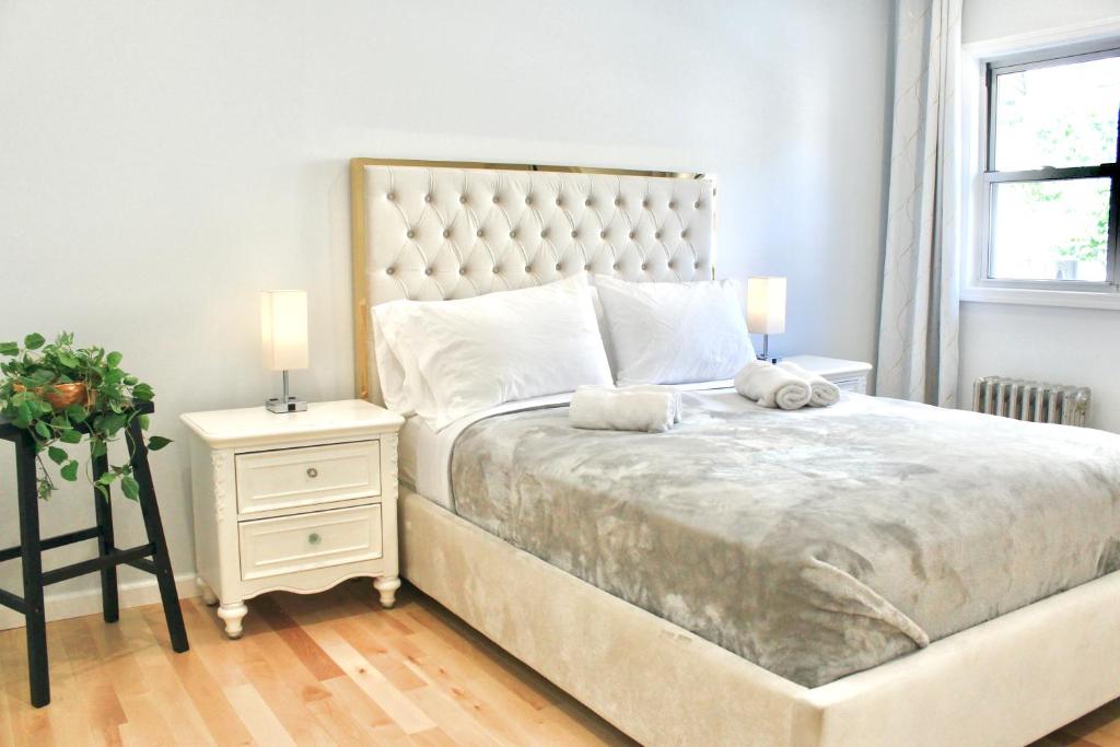 a bedroom with a large bed and a night stand at 2-Bedroom Apartment 15 Minutes From Manhattan in LIC Astoria Queens 