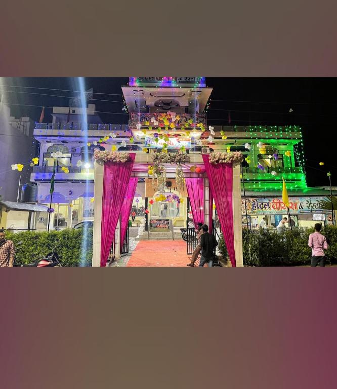 a large arch with pink drapes in front of a building at Hotel Veeras in Palāi