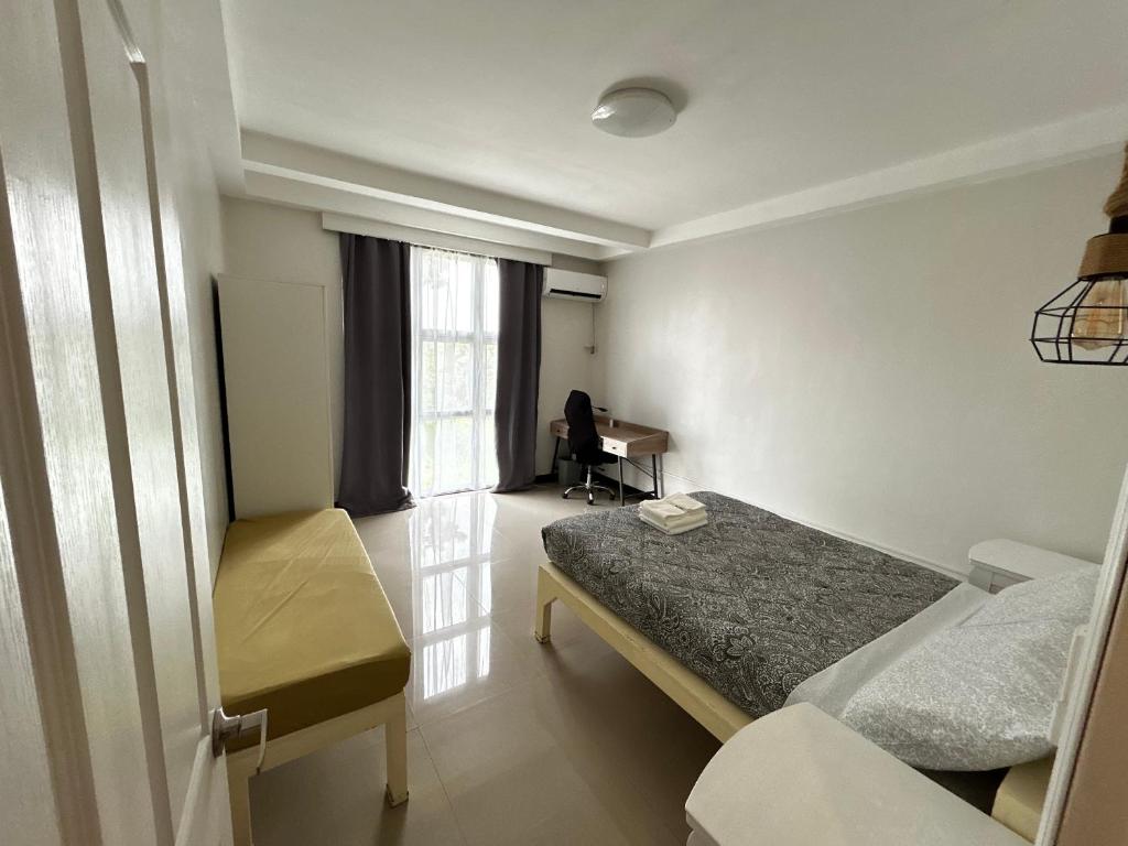 a bedroom with a bed and a desk in it at Kuya and Kambal's 1 BR 1 Bath Apartment in Manila