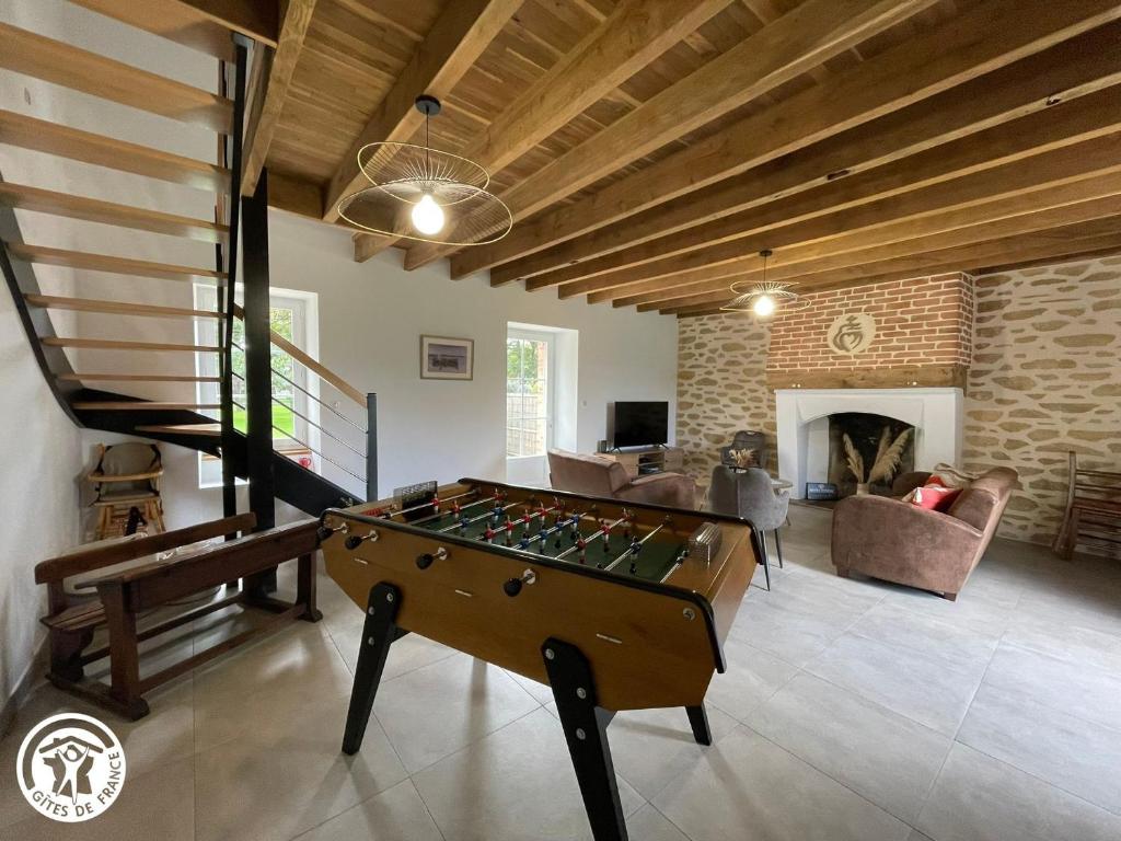 a living room with a pool table and a fireplace at Maison familiale avec babyfoot et piscine chauffée - FR-1-426-597 in Soullans
