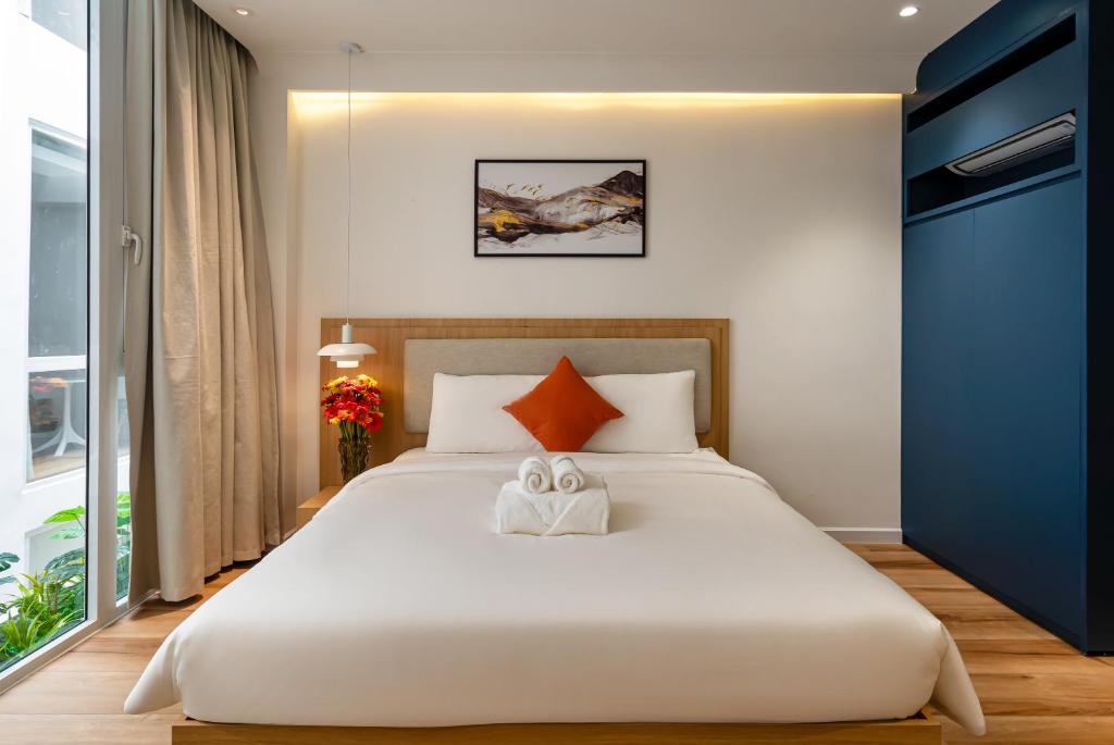 een slaapkamer met een groot wit bed en een raam bij APEC WANDER HOTEL - Near Tan Dinh Market in Ho Chi Minh-stad