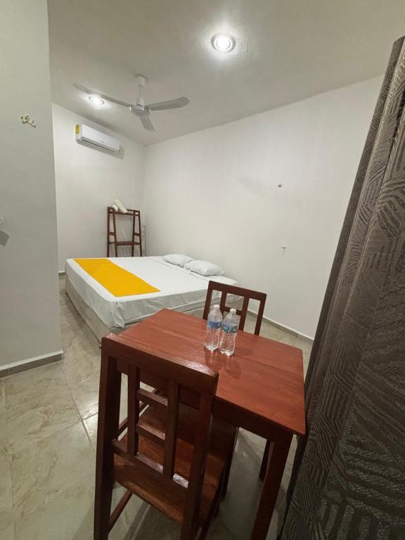 a bedroom with a bed and a table and chairs at Departamento AF2 in Tizimín