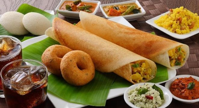 a plate of food with a sandwich and onion rings at Neo Elite Inn in Puducherry