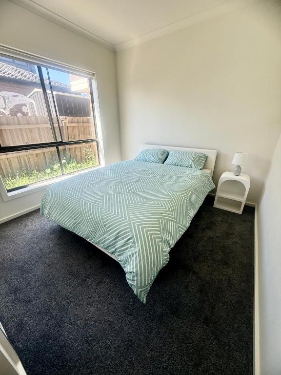 a bedroom with a bed with a large window at Peaceful Private Room in Wyndham Vale in Wyndham Vale