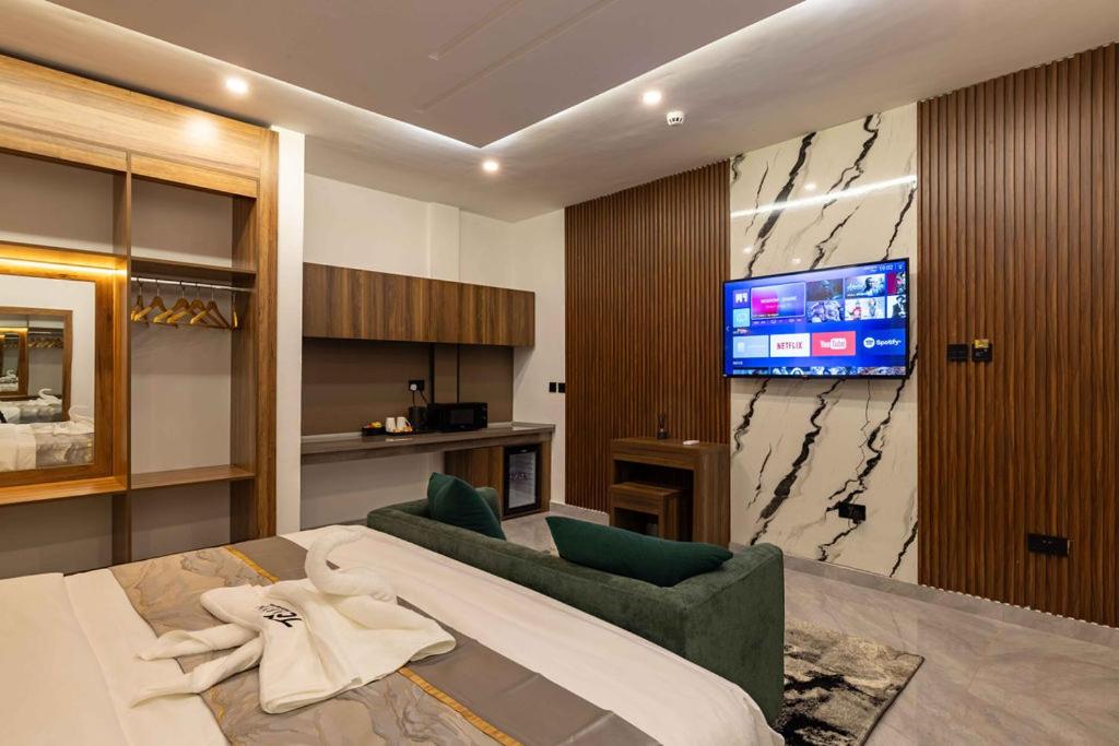 a bedroom with a large bed and a tv at The Cabyn in Accra