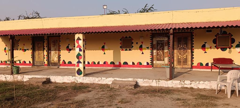 a building with a table and chairs in front of it at Rann Roshni homestay in Bherandiāla