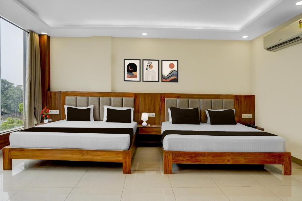 two beds in a room with two at Super Townhouse Varanasi City Station Formerly S Kumar Inn in Varanasi