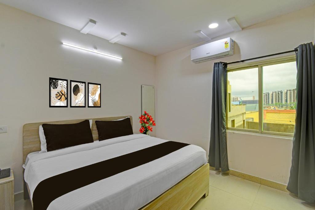 a bedroom with a large bed and a window at Super Collection O White Field Road Hyderabad Formerly Ayaan Signature Suites in Kondapur