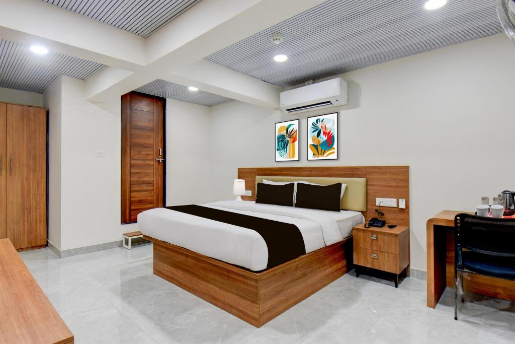 um quarto com uma cama e uma escrivaninha em Super Hotel O Pune Kasarwadi Railway Station em Pune