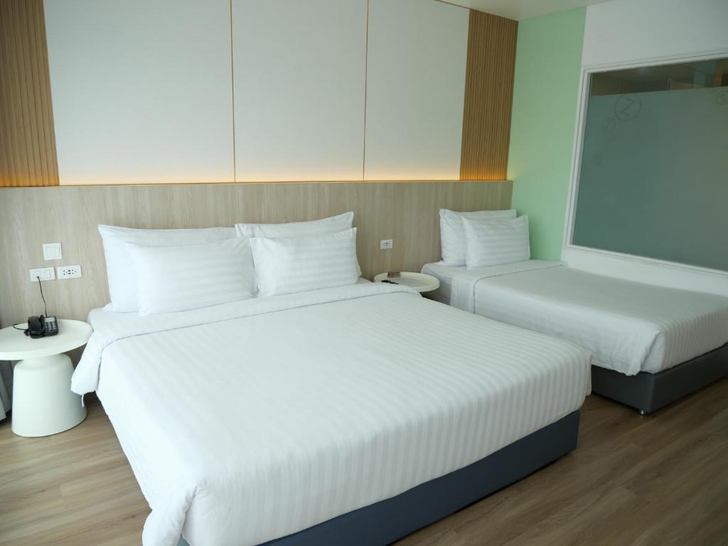 a hotel room with two beds and a mirror at SLEEP WITH ME HOTEL design hotel @ patong (SHA Plus+) in Patong Beach