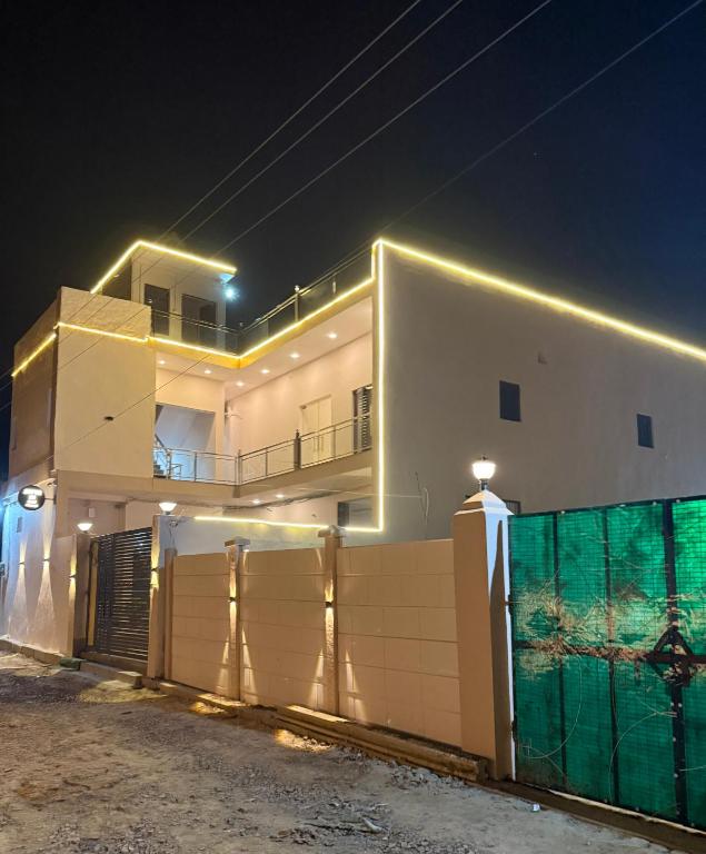 a white house with a fence in front of it at night at Hotel Jaipur In, Jatipura Parikrama Marg Near Mukharvind Temple in Govardhan