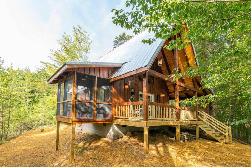 a tree house with a large deck in the woods at Pet-Friendly Tiny Cabin - Pine Point in Pine Ridge