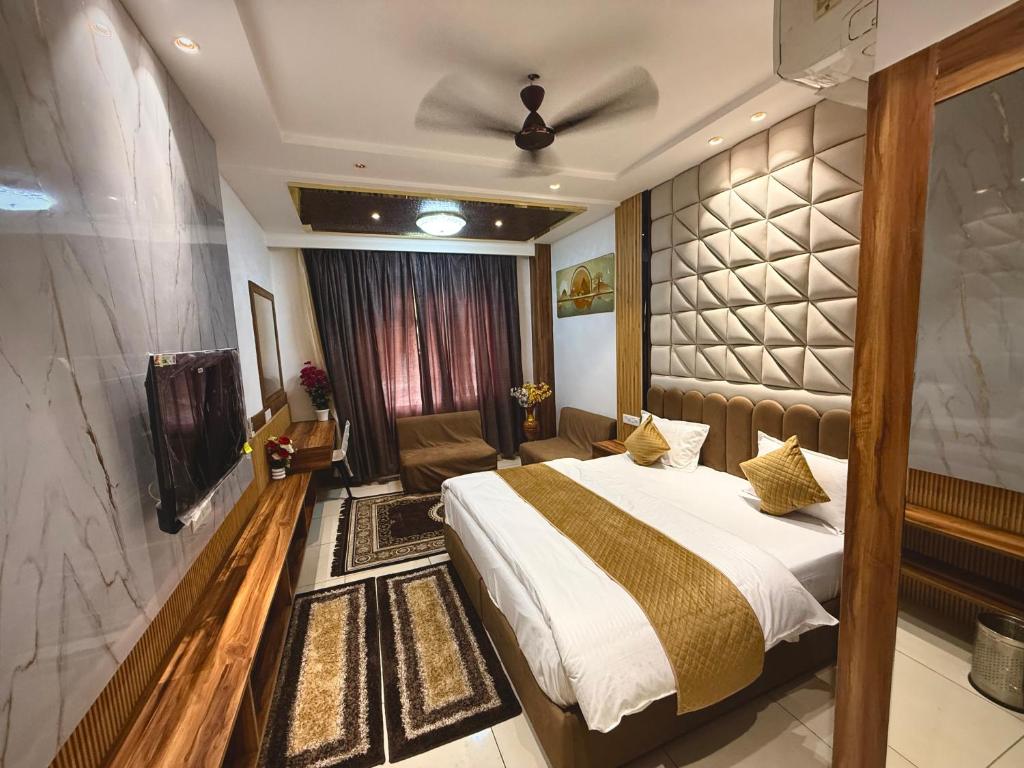 a hotel room with a bed and a television at The Grand's in Jagādhri