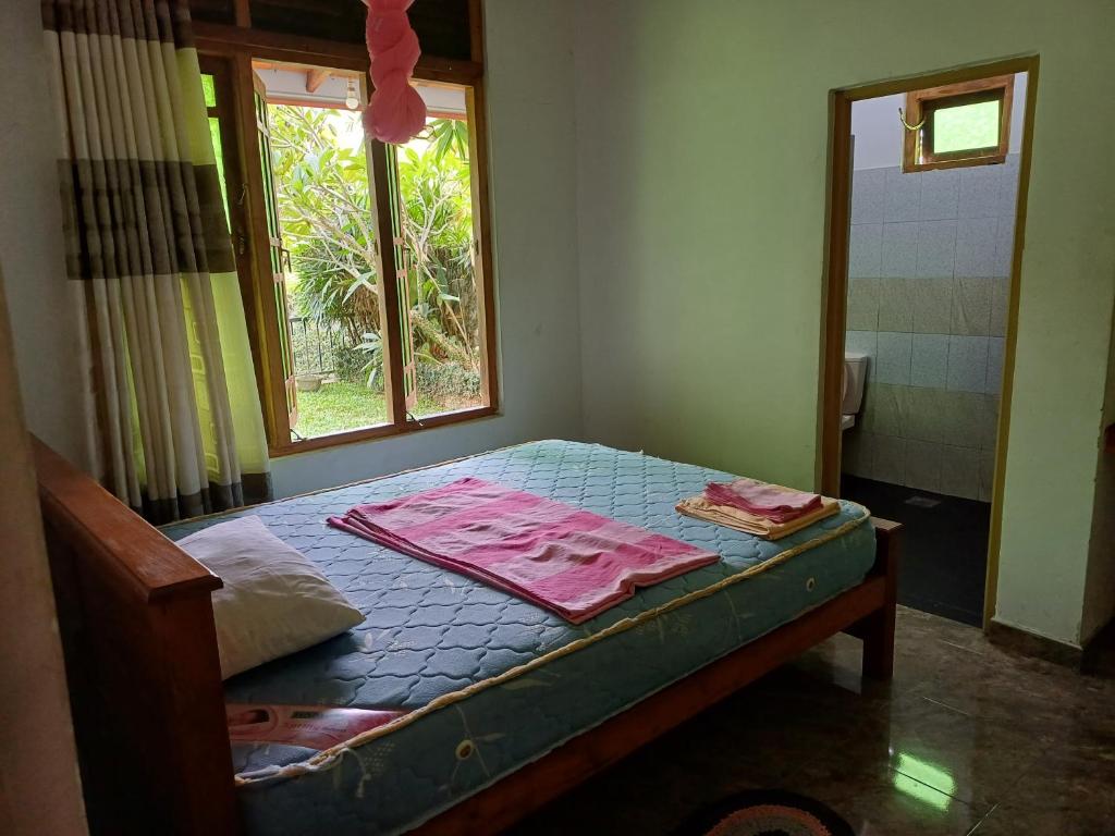 a small bedroom with a bed with a window at Elephant View Hotel in Damana