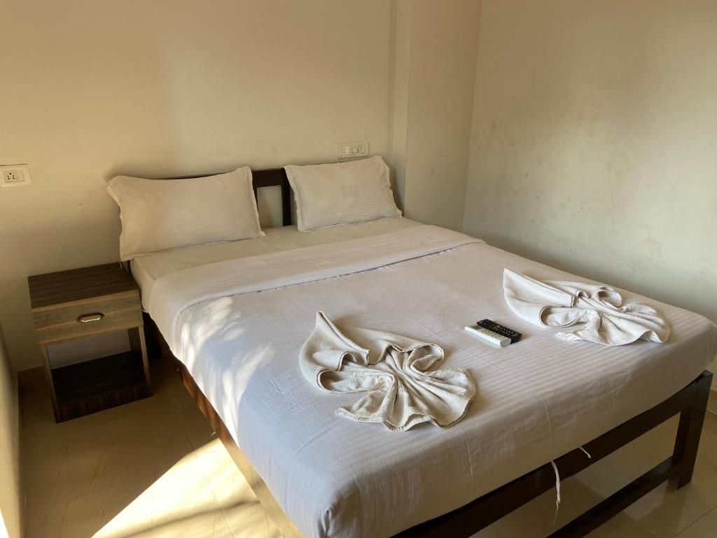 卡兰古特Tivai Beach Hotel的一张带白色床单和白色毛巾的床