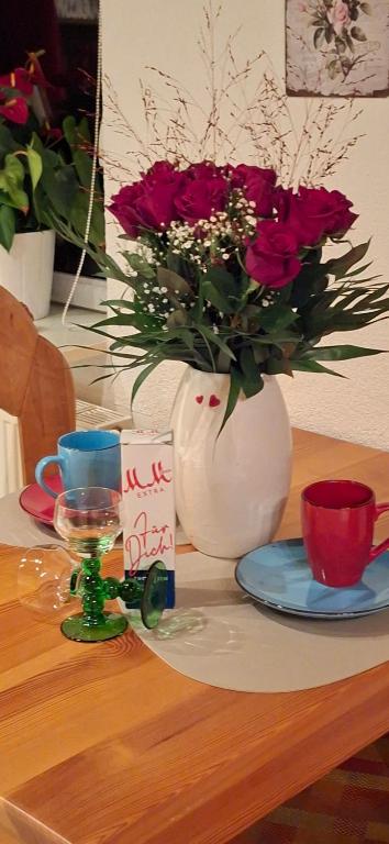 a table with a vase with red flowers in it at Martha in Langenchursdorf