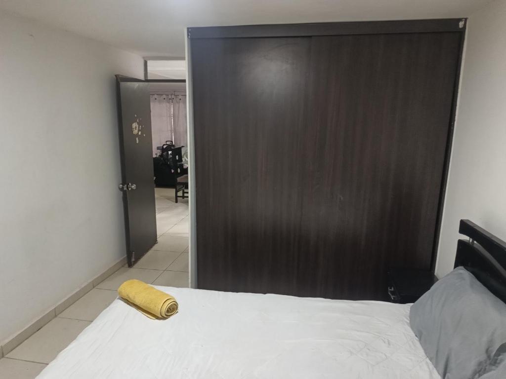 a bedroom with a large bed and a wooden door at 2 habitaciónes 3 baños in Cúcuta