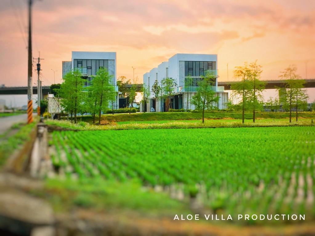 a large building with a field in front of it at 蘆薈villa民宿 in Wujie
