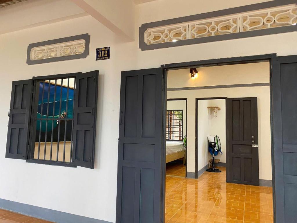 a room with black doors and a bedroom at Homestay Nhà Của Gạo in Ấp Thiẹn Ái