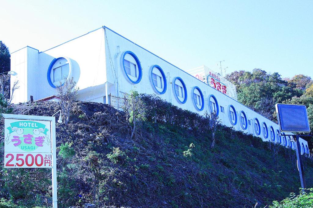 a building with a sign on the side of a hill at ホテル うさぎ -岡山運転免許センター南- 