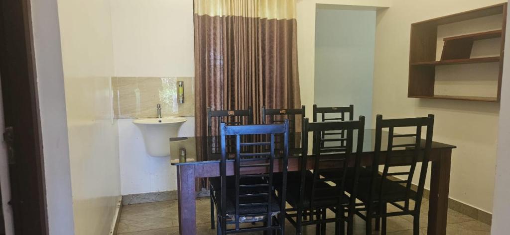 a dining room with a table with chairs and a sink at Munnar 4 bedrooms family villa in Munnar