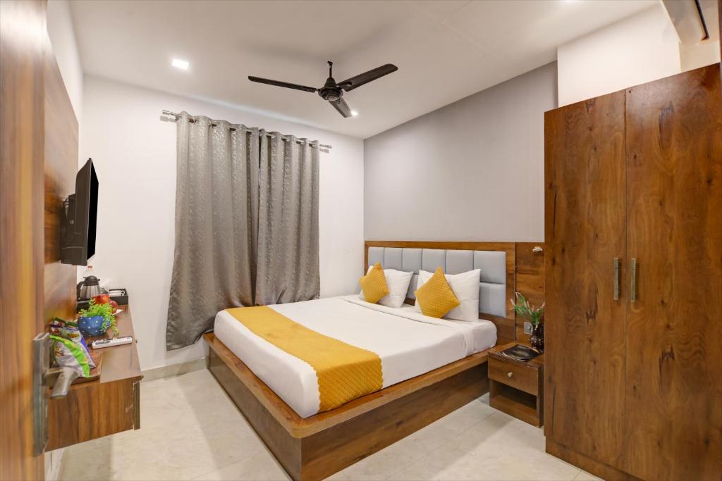 a bedroom with a bed with yellow and white sheets at Hotel Travana Stay at Pitampura in New Delhi