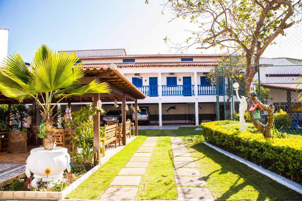 a house with a garden in front of it at Pousada Recanto Sol a Sol in Cabo Frio