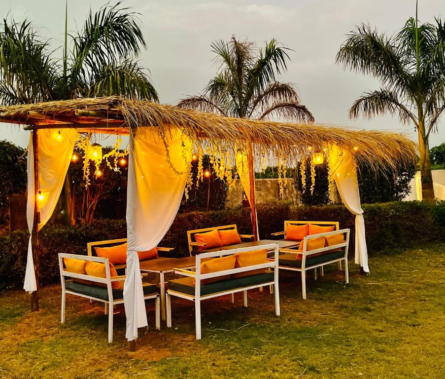 a table and chairs under a thatch canopy with lights at Heaven hill Pushkar in Pushkar