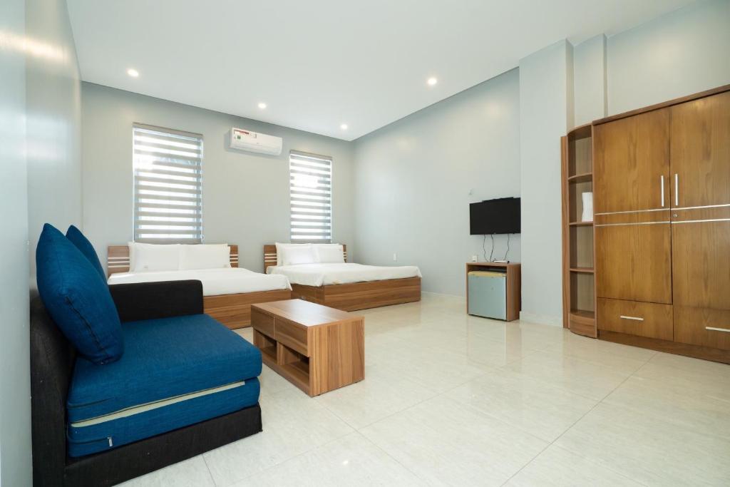 a living room with a couch and a bed and a tv at Bona Hostel in Da Nang