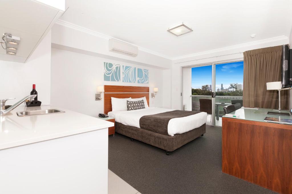 a hotel room with a large bed and a large window at Hotel Chino in Brisbane