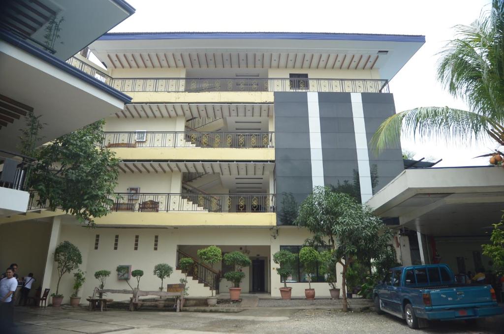 un edificio con un camión azul estacionado frente a él en Reyna's the Haven & Gardens en Tagbilaran City