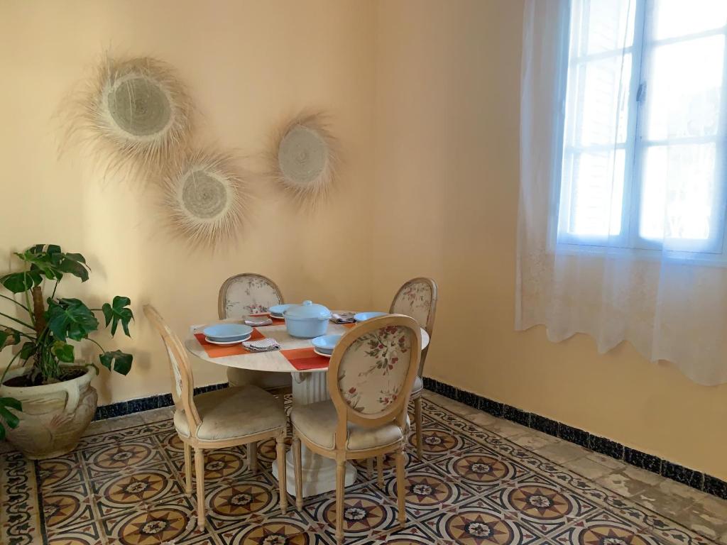 a dining room with a table and chairs and a window at Petite maison typique à 2 pas de la mer in Sousse