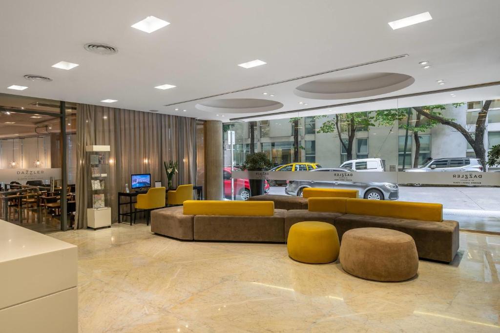 a lobby with a couch and some yellow chairs at Dazzler by Wyndham Polo in Buenos Aires