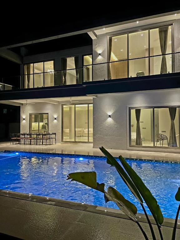 a large swimming pool in front of a house at Exotica Stays in Alibaug