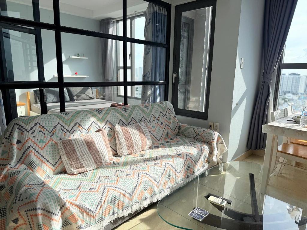 un soggiorno con un divano e un tavolo di vetro di Stay With Me CBD Apartment - Rivergate Building ad Ho Chi Minh